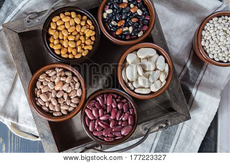 Assortment of beans on black wooden background. Soybean red kidney bean black beanwhite bean red bean and brown pinto beans
