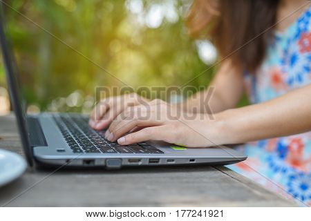 woman hand hold smart phonemobilecell phone over blurred image of officenotebookcoffee cupabstract green nature backgroundblur image