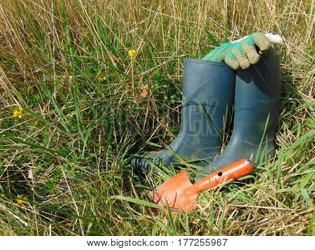 Garden work / rubber boots in grass with small shovel