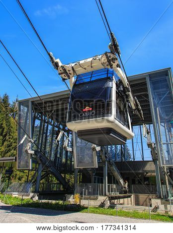 Mt. Stanserhorn, Switzerland - 8 May, 2016: a gondola of the Cabrio cable car starting its way to the top of the mountain from the Kalti station. Stanserhorn Cabrio is the the world's first double deck open top cable car.