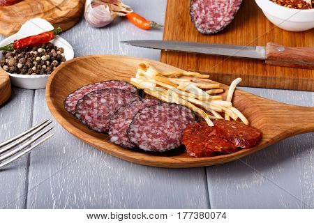 Snack set. Variety of salami and cheese chechil. Rustic style.