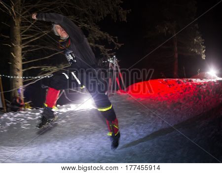 ALMATY, KAZAKHSTAN - 18 FEBRUARY 2017: Night competitions in the foothills of the city of Almaty, in the Trailrunning and Skyship discipline, which is called TunRun winter edition. Man running in the mountains at night.