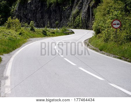 double bend in the road in a mountain landscape in stone with the blue sky as the background