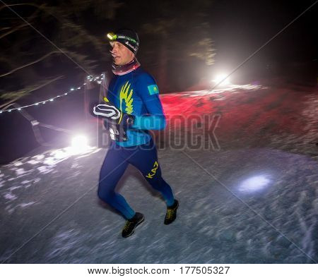 ALMATY, KAZAKHSTAN - 18 FEBRUARY 2017: Night competitions in the foothills of the city of Almaty, in the Trailrunning and Skyship discipline, which is called TunRun winter edition. Man running in the mountains at night.