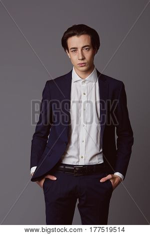Business fashion man wearing blue suit with white shirt. Studio shot against grey. Processed with VSCO s3 preset