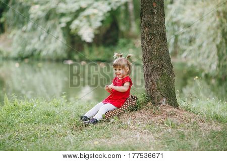 girl in a red dress walking and playing in the summer park