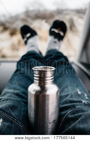 Vertical Photo Of Woman Feet In Cute Socks And Jeans On Car Dashboard. Drinking Water On Road. Trave
