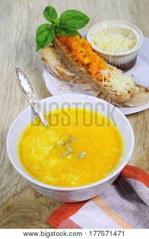 Carrot soup with bread topped and grated cheese
