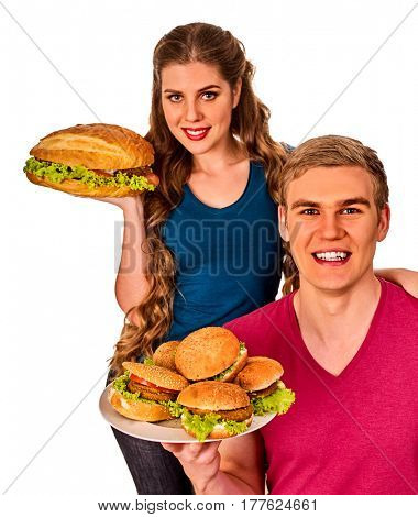Couple eating fast food. Man and woman eat hamburger with ham . Friends holding two burder junk and offer treats on white background isolated.