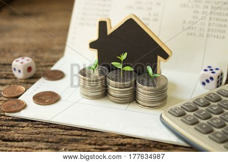 stack coins and house wood model green plant growthconcept idea for save and growth money