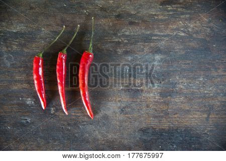 Red hot chilli peppers on the wooden table background