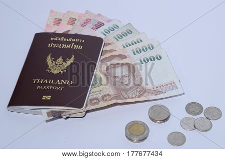 Thailand passport with insolated white background and copy space thai baht banknotes and coins
