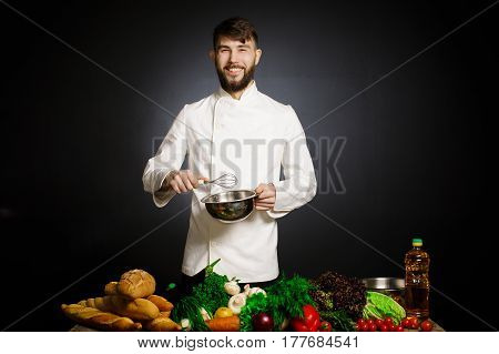 Cook chef with vegetables splah and black dark background. Food musical harmony. Chef juggling with vegetables and other food in the kitchen.