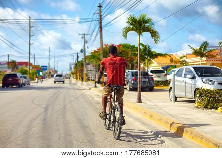 BAVARO DOMINICAN REPUBLIC - 09.01.2015: Undefined man riding on bicycle along the Bavaro city road