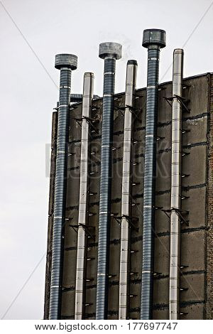 Fuming industrial pipe on the factory wall