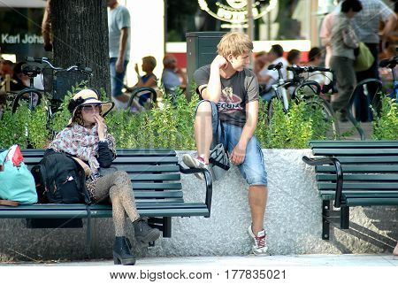 Oslo Norway - July 22 2014: teenagers relax in the park Eidsvolls Plass located on the main street Karl Johans Gate