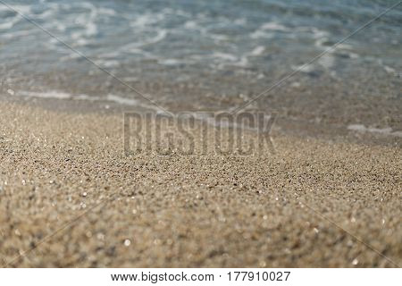 Beautiful sand at Kleopatra beach in Alanya turkey with sand in center of image in sharp focus and blurred wave and sand on foreground and background.