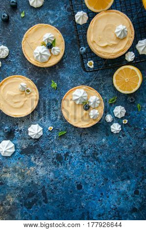 Lemon Curd And Blueberry Jam Tarts With Meringue And Basil Leaves Chamomiles Whole And Slices Of Fre