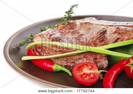 cibo di carne: arrosto nervatura sul piatto scuro con timo pepe e pomodoro isolato su sfondo bianco. Sha