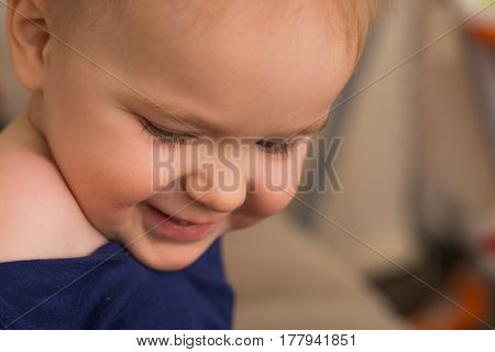 Beautiful happy little caucasian boy (white) 2-3 years close-up looking down and smiling