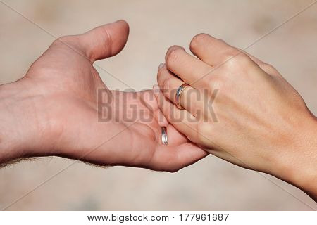 Close up shot of two beautiful hands with wedding rings