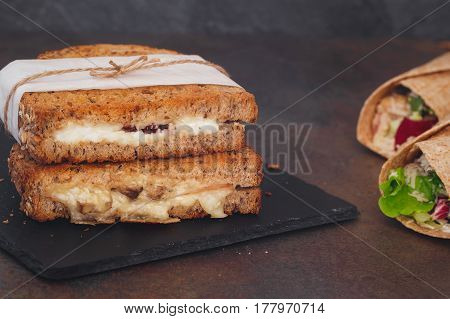 Sandwiches wrapped in paper and tortilla wraps.  Macro, selective focus, blank space.