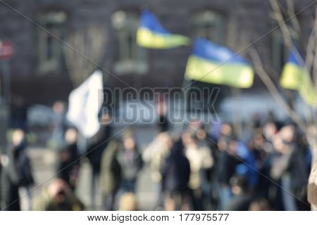 Crowd of people walking on busy city street, blurred view