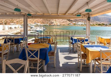 Sifnos, Greece - September 10, 2018: Tables With Chairs On Coastal Promenade. Sifnos Island, Greece