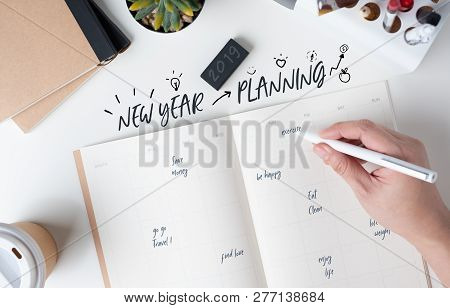 Top View Of Hand Writing  New Year's Planning On Open Calendar Planner With Doodle Style For Life Re