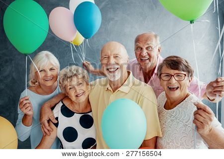 Happy Senior People With Colorful Balloons During Friends Party