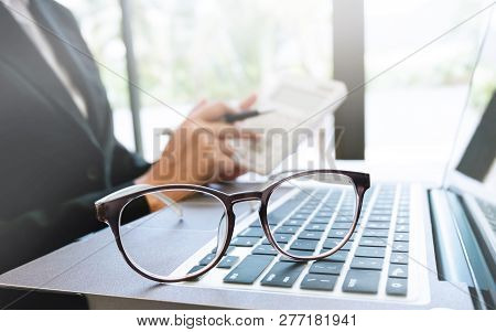 Business Executive Working On Caculator Selective Focus On Eyeglasses