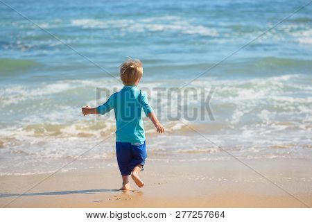 Happy Boy Running On The Beach In The Waves