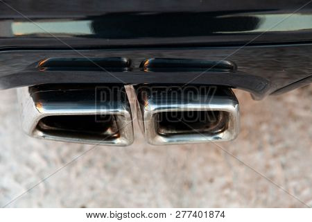 New Shiny Chrome Pipes Close-up After Tuning And Installation On The Back Of A Black Car In The Tail