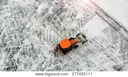 Aerial. Snow Removal With A Tractor On A City Parking Lot.