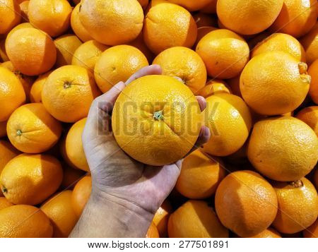 Pick Up Orange Navel In Market Place At Supermarket.