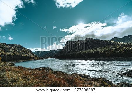 A Stunning Wide-angle View Of The Riverbank In The Mountains; Katun River Surrounded By Hills Overgr