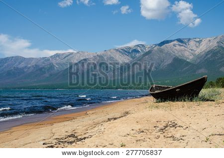 Very Old Wooden Fishing Boat Aground On The Beach, Near Lake Baikal, Russia, On A Sunny Day In The S