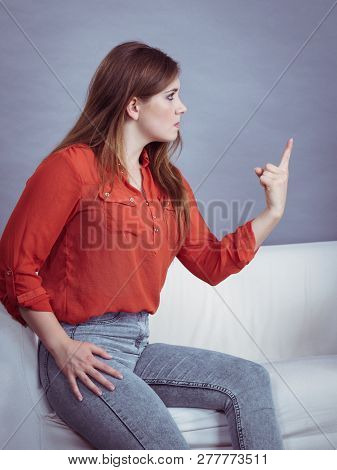Angry, Pissed Off Young Woman. Attractive Female With Long Brown Hair Sitting On Sofa Being Mad And 