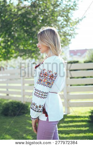 Beautiful Young Woman In Traditional Ethnic Ukrainian  Style. Vyshivanka Blue With White Embroidery