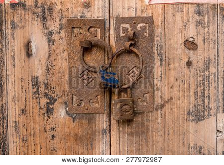 Rusty Padlocks Link The Circular Iron Handles On Wooden Doors In Ancient Chinese Doorway