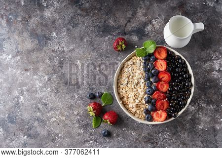Healthy Breakfast, Muesli With Currants, Blueberries And Strawberries In Bawl On Dark Backgrund