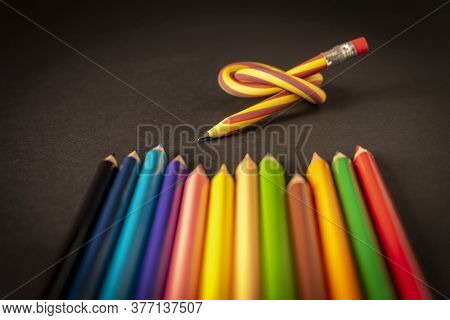 Flexible Pencil And A Set Of Colored Pencils On A Dark Background. Selective Focus