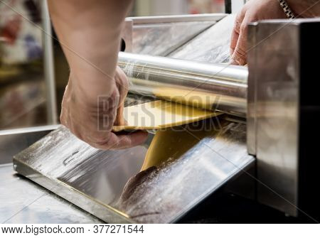 Chef Rolling Dough With A Pasta Machine. Pasta Maker Machine.