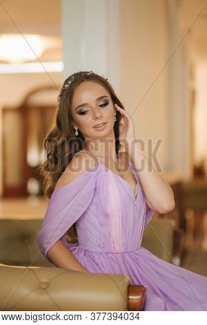 Young Woman In Beautiful Purple Dress Posing To Photographer By The Restaurant