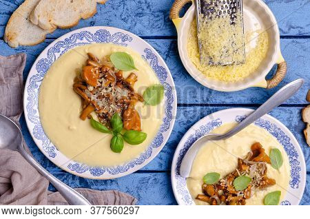Traditional Polenta With Mushrooms And Cheese In A Dish On A Blue Wooden Background. Selective Focus