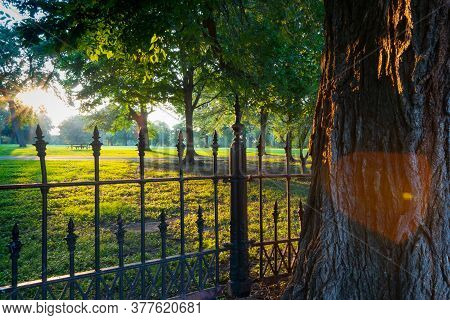 Long Shadows Through Wrought Iron Fence Surrounding La Fayette Park With Lens Flare  Effect At Sunse