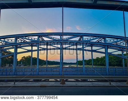 Blue Metal City Bridge With Road Over Odra River At Sunset