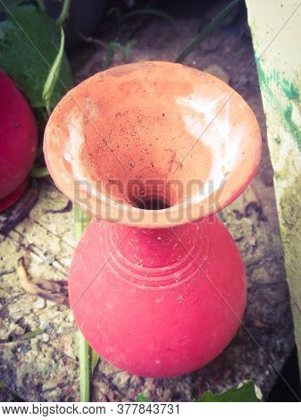 Top Angle View Of A Red Colored Earthen Pot Placed In A Garden For Decoration.the Mouth Is Large And