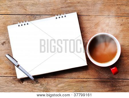 Varm kaffe med note på træ baggrund
