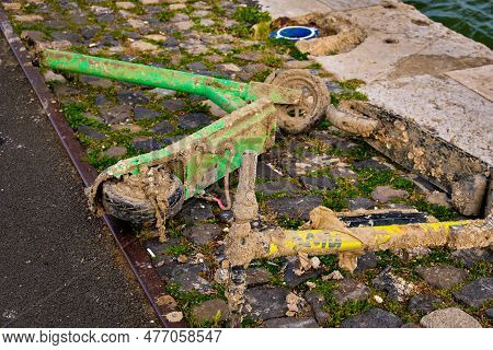 Kick-sharing Rental Electric Scooters Retrieved From Water, Covered In Mud And Garbage, Lie By Water